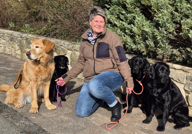 Stephanie Koppe, kniend, mit 4 Hunden